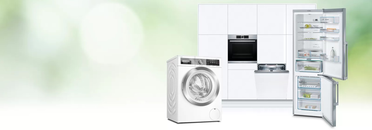 Wasmachine, oven, vaatwasser en open koelkast in een lichte en moderne keuken.