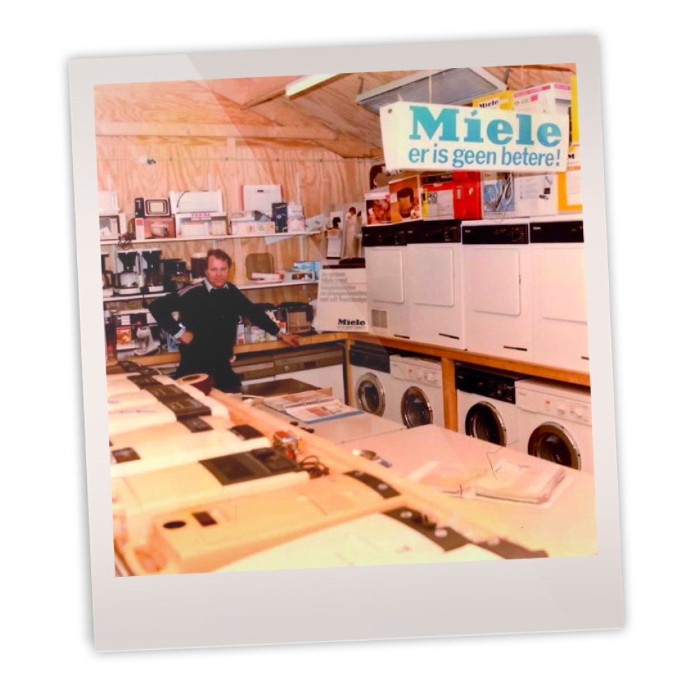 Winkelinterieur met diverse huishoudelijke apparaten en een bord met "Miele er is geen betere."