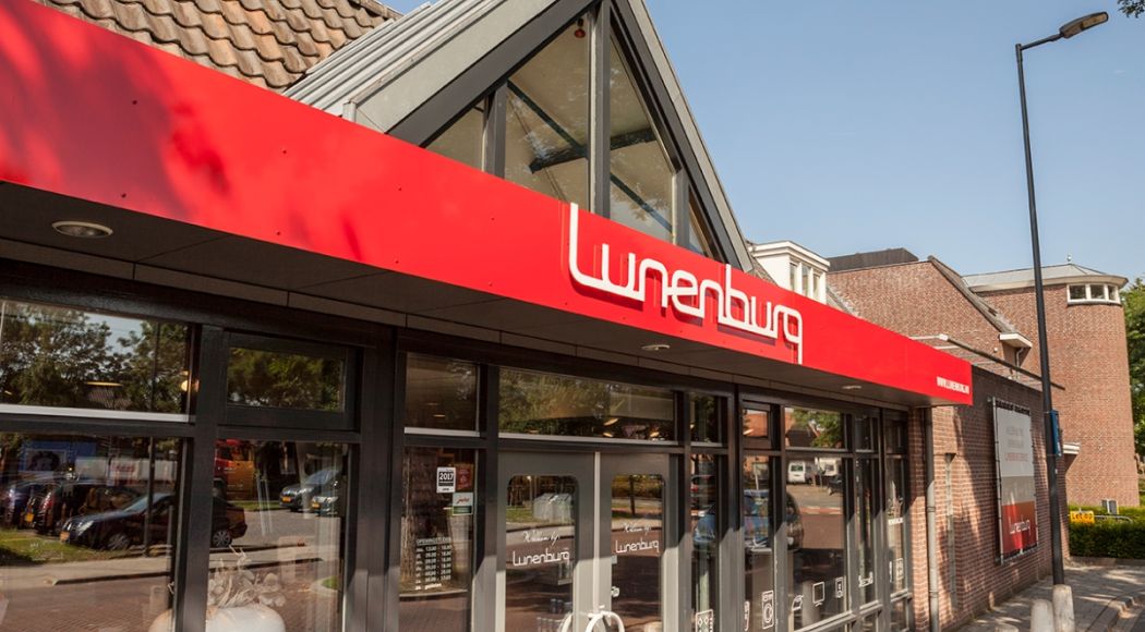 Buitenkant van een winkel met rode luifel en de naam "Lunenburg".