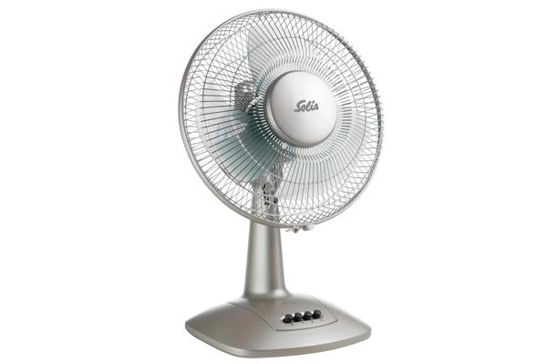 Tafelventilator met zilveren behuizing en rooster, staande op een voet met bedieningsknoppen.