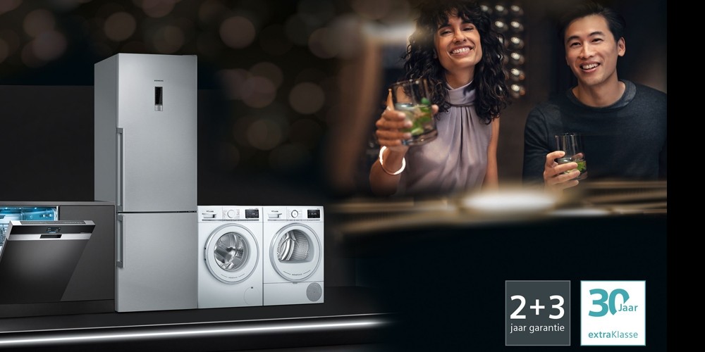 Afbeelding van moderne keukentoestellen zoals een koelkast, vaatwasser, wasmachine en droger, met daarnaast een lachend koppel dat een drankje vasthoudt. Links onderaan zijn garantie- en servicelogos te zien.